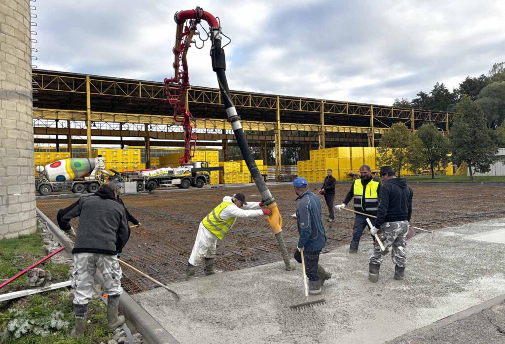 Ruční rozprostírání a hutnění čerstvého betonu pomocí betonového čerpadla.
