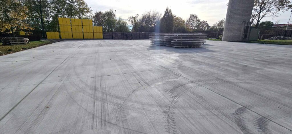 Dokončená betonová zpevněná plocha v průmyslovém areálu.