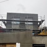 Detail rozestavěného rodinného domu s lešením a hrubou fasádou